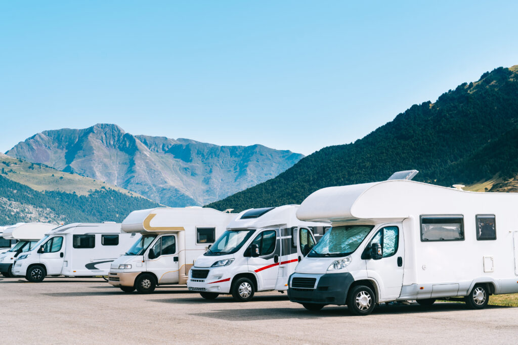 RV's parked alongside each other with mountains in the background.